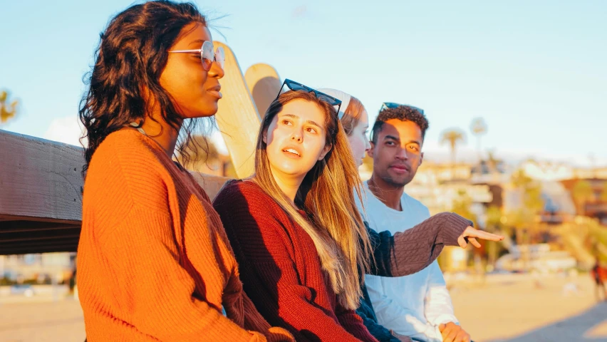 a group of people sitting on top of a wooden bench, trending on pexels, warm coloured, teenage girl, oceanside, background image