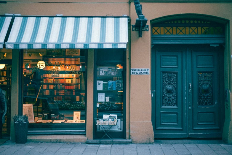 a store front with a green and white awning, a photo, pexels contest winner, neoclassicism, book shelf small library, swedish, 90's photo, warm glow
