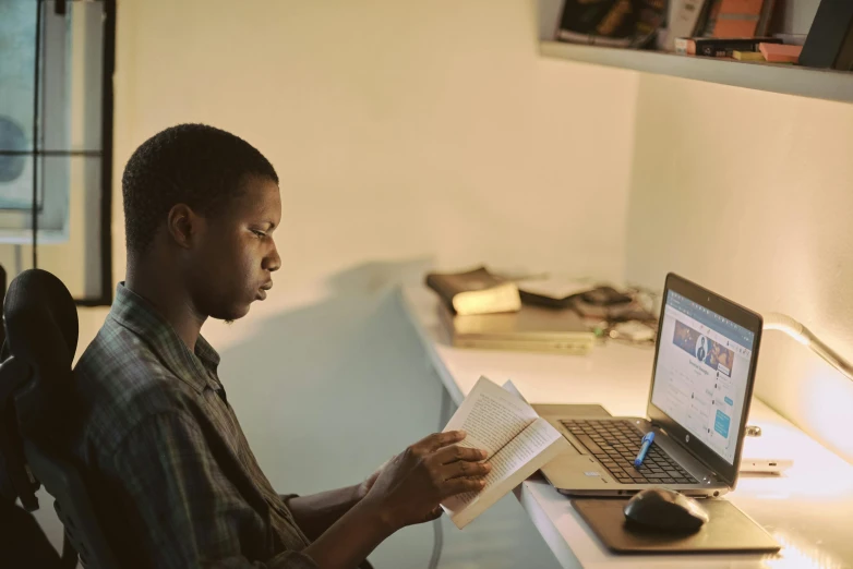 a man sitting at a desk reading a book, by Carey Morris, pexels contest winner, afro tech, still from the movie ex machina, google arts and cultures, in front of the internet