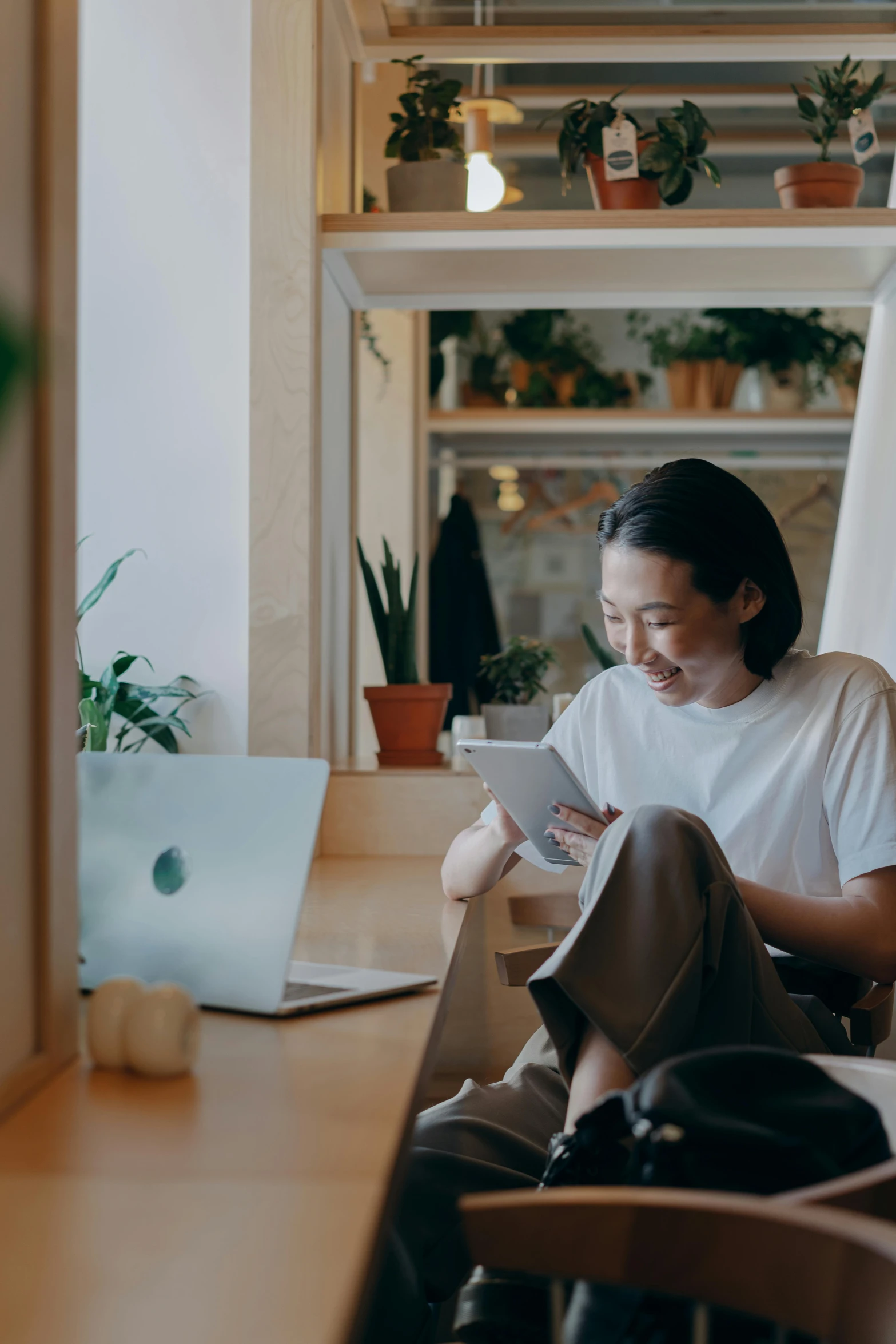 a woman sitting on a chair in front of a laptop, by Jang Seung-eop, trending on unsplash, happening, looking at his phone, airbnb, asian male, a still of a happy