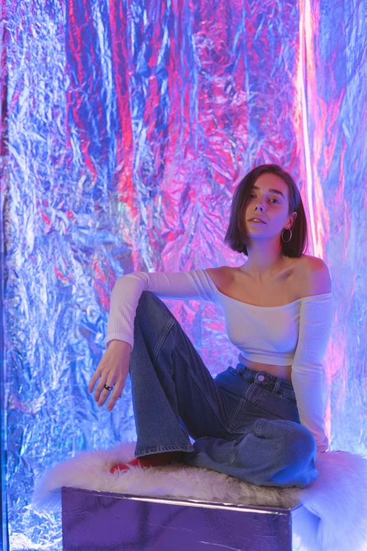 a woman sitting on top of a box in a room, inspired by Elsa Bleda, trending on pexels, holography, :: madison beer, low saturated red and blue light, stood in a tunnel, sydney hanson