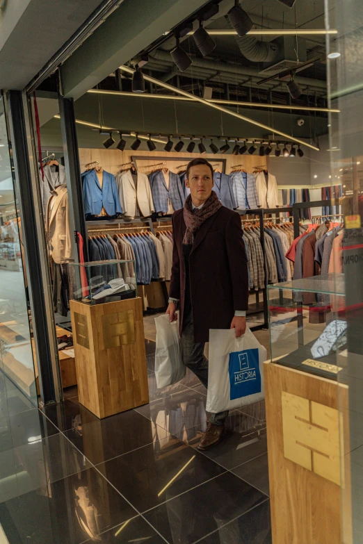 a woman standing in front of a clothing store, by Daniel Gelon, happening, handsome man, shopping mall, press shot, facing front