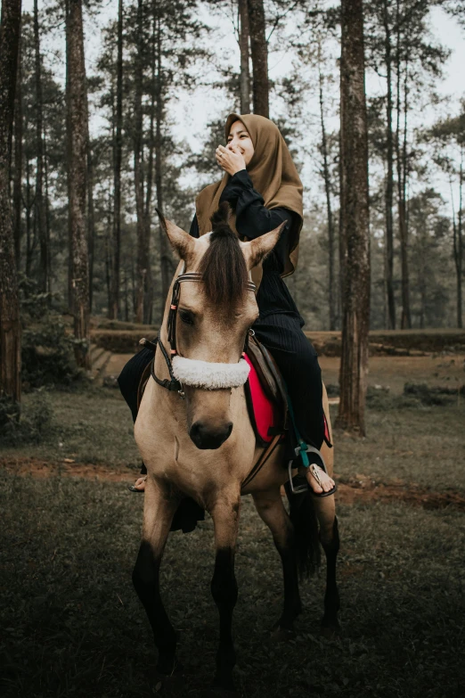 a woman riding on the back of a horse in a forest, by Basuki Abdullah, unsplash contest winner, handsome girl, gif, islamic, instagram story