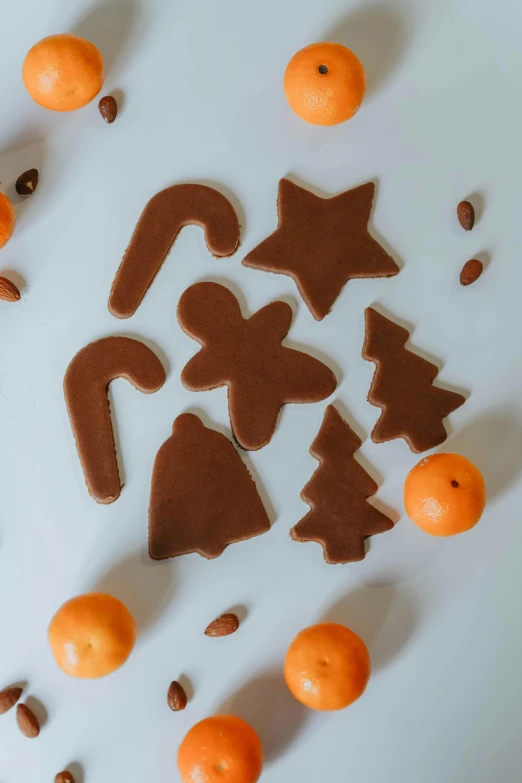 a white plate topped with chocolate and oranges, gingerbread people, premium, thumbnail, essence