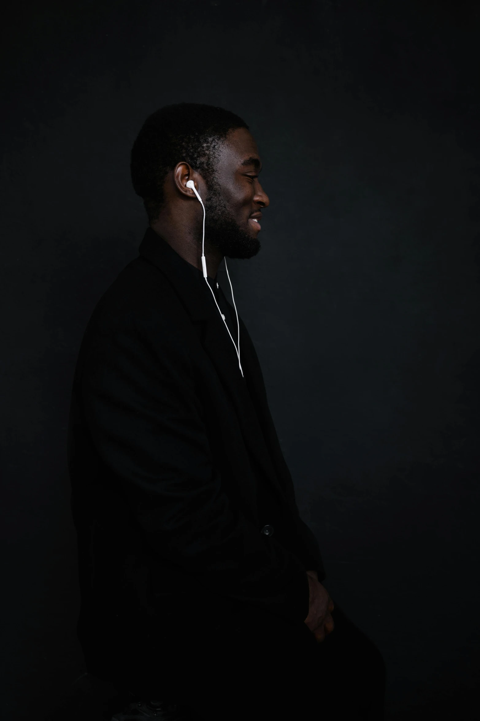 a man wearing headphones in a dark room, an album cover, by Stokely Webster, trending on pexels, les nabis, elegant profile pose, jaylen brown, without text, headshot profile picture