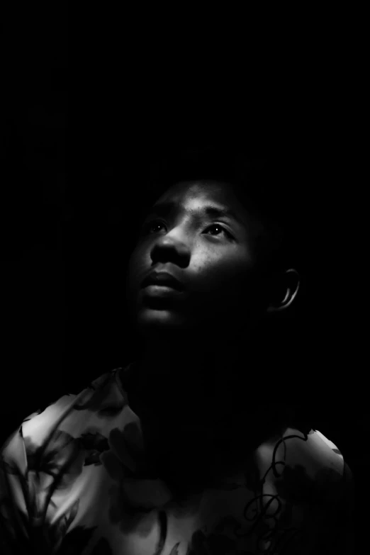 a black and white photo of a man in the dark, by Abidin Dino, black teenage boy, peaceful expression, kano), he is about 20 years old | short