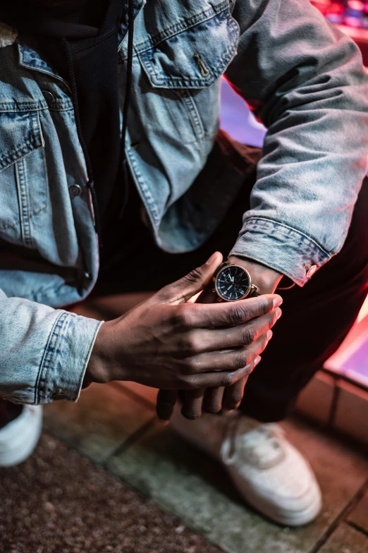 a man sitting on the ground holding a cell phone, trending on pexels, visual art, wears a watch, stern blue neon atmosphere, frank moth, close-up shoot