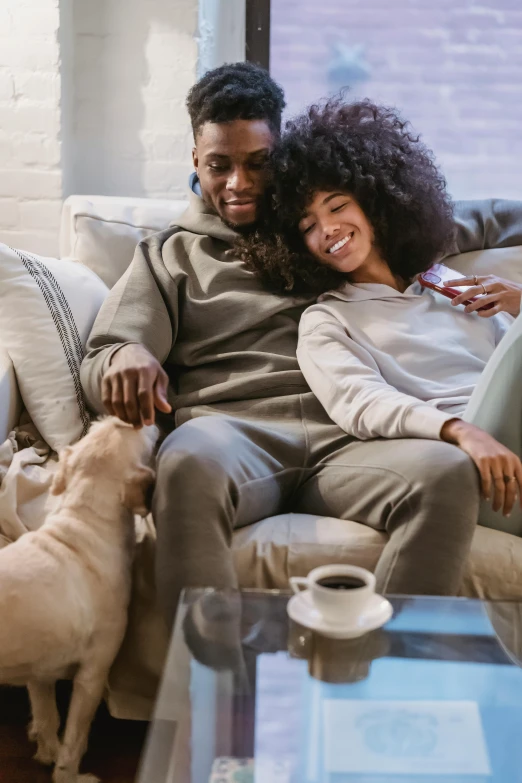 a man and woman sitting on a couch with a dog, black man, supportive, romantic lead, connectivity