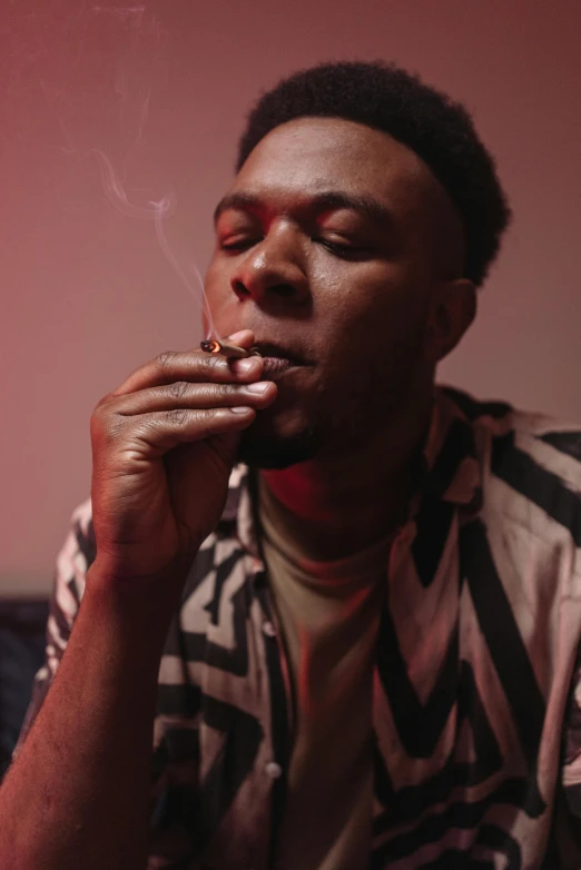 a man sitting on a couch smoking a cigarette, an album cover, trending on pexels, brown skinned, mid night, portrait of tall, young man