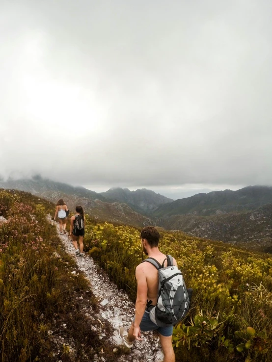 a couple of people that are walking on a trail, pexels contest winner, happening, a wanderer on a mountain, australian bush, sweaty mountain, on a cloudy day