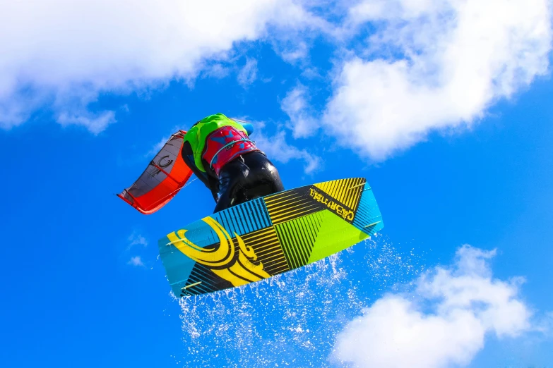 a man flying through the air while riding a snowboard, by Niko Henrichon, unsplash, figuration libre, chartreuse and orange and cyan, over water, avatar image, kites