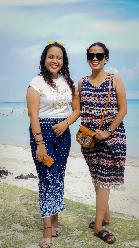 two women standing next to each other on a beach, a picture, inspired by Gina Pellón, sumatraism, low quality photo, fullbody, digital image, holiday