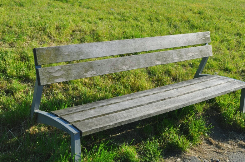 a wooden bench sitting on top of a lush green field, pixabay, realism, public space, missing panels, some people are sitting, sittin