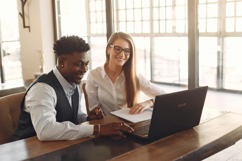 a couple of people sitting at a table with a laptop, trending on pexels, professional profile picture, brown, lachlan bailey, teaching