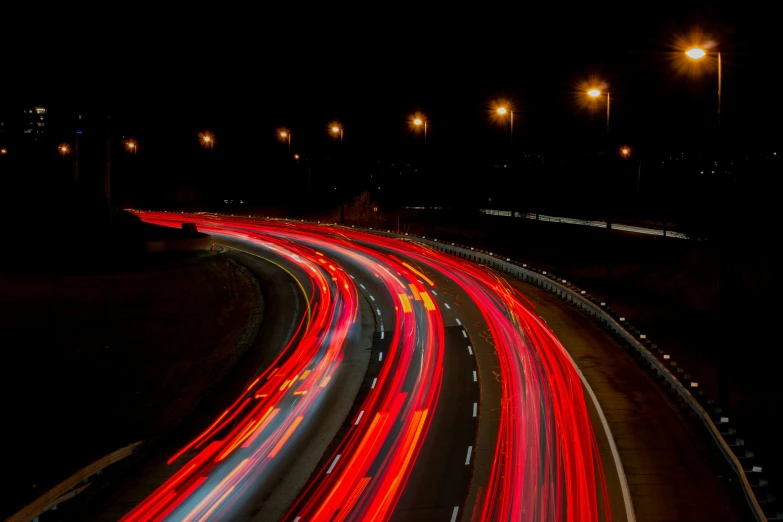 a highway filled with lots of traffic at night, an album cover, pexels contest winner, visual art, red tail lights, speed lines, curving, 1 4 9 3