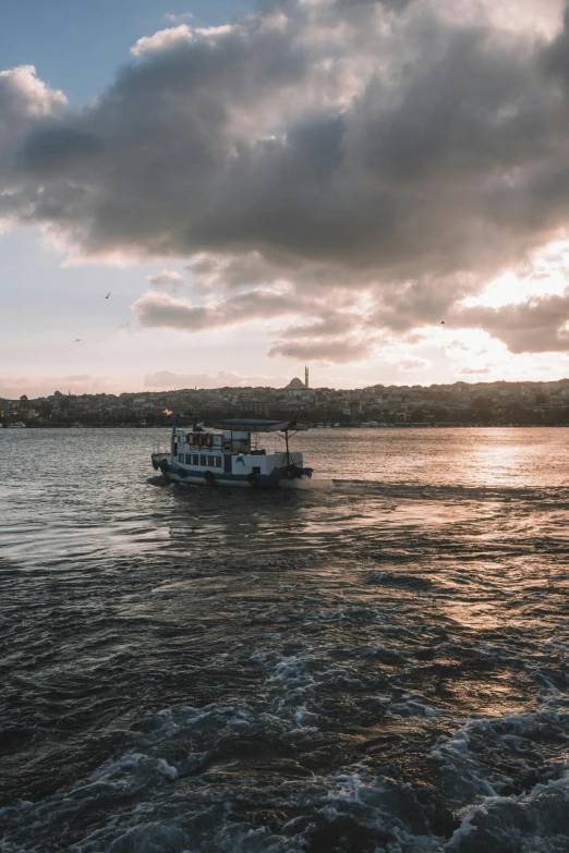 a boat on a body of water under a cloudy sky, istanbul, slide show, golden hour photograph, multiple stories