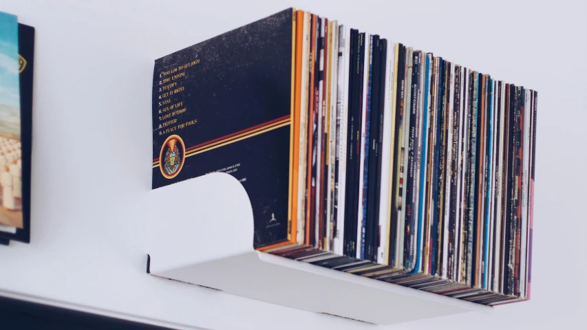 a shelf that has a bunch of records on it, an album cover, by Ottó Baditz, unsplash, funk art, glossy white, 3d printed, panorama, woodstock