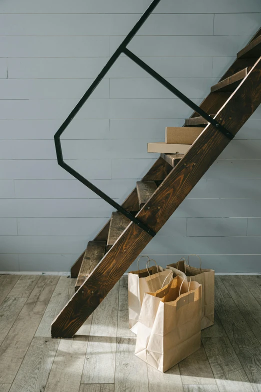 a wooden staircase next to a paper bag on a hard wood floor, unsplash, modernism, dwell, bakery, - 9, straps