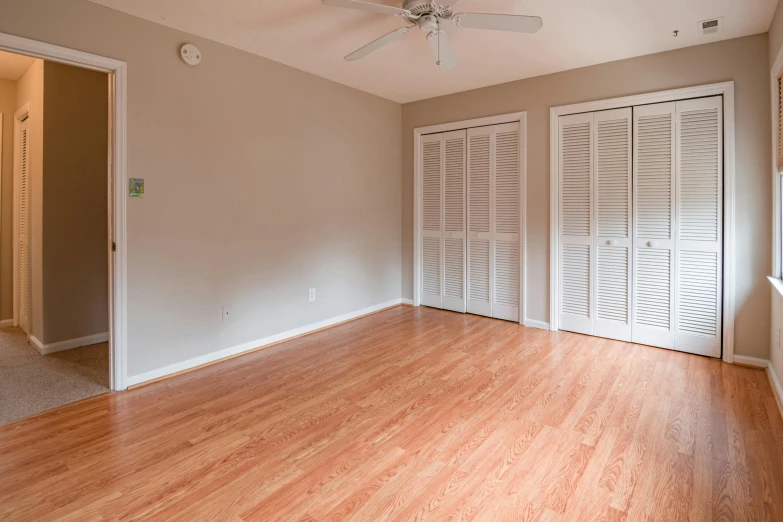 a room with hard wood floors and a ceiling fan, by Carey Morris, unsplash, high quality photo, basic white background, fan favorite, doors to various bedrooms