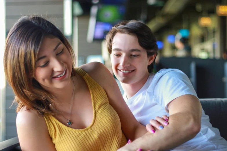 a couple of women sitting next to each other on a couch, pexels contest winner, happening, teen boy, sitting at a bar, avatar image, holding close