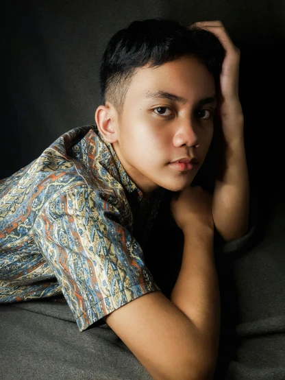a young man laying on top of a couch, inspired by Rudy Siswanto, androgynous face, patterned, ((portrait)), trending photo