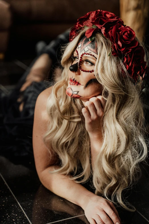 a woman laying on the floor with her face painted, by Heather Hudson, trending on pexels, skull made of red roses, close up of a blonde woman, profile image, elaborate costume