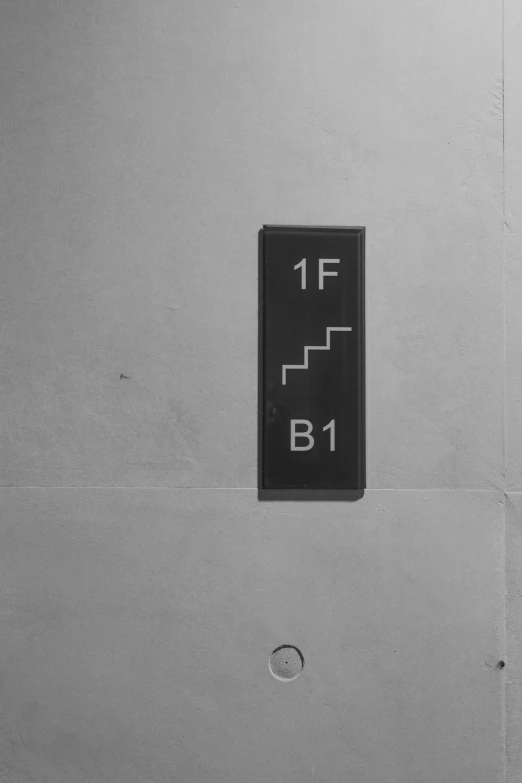 a black and white photo of a sign on a wall, an album cover, by Bauhaus, elevator, f 1.4, 1 - bit, ignant