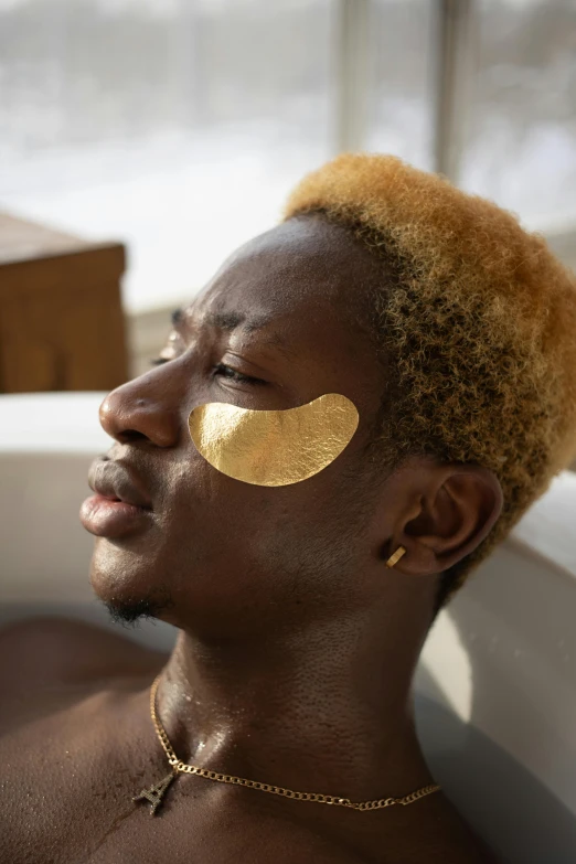 a man in a bathtub with gold foil on his face, trending on pexels, afrofuturism, black eye patch over left eye, sunny day, gold bra, spa