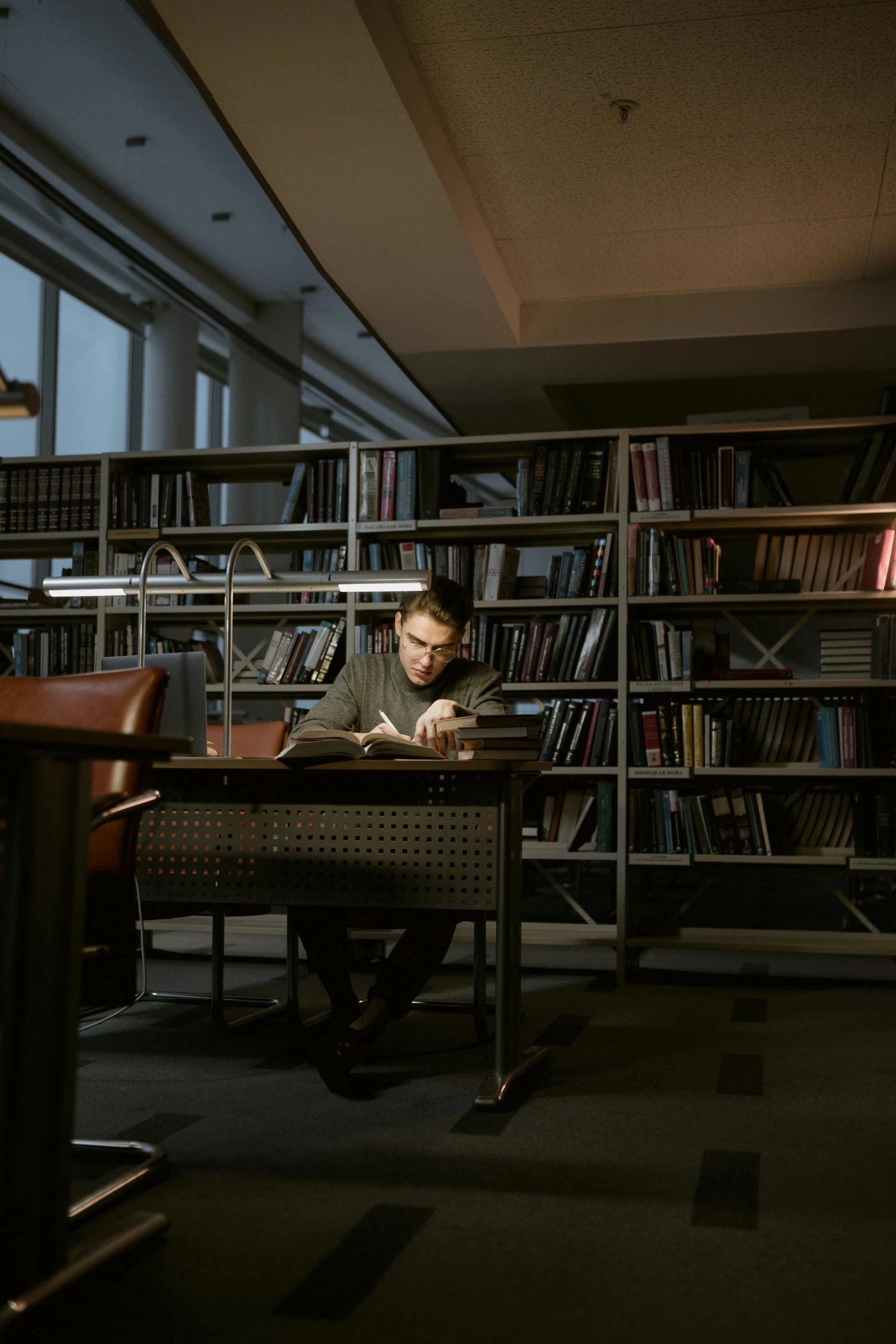 a man sitting at a desk in a library, a portrait, by Fei Danxu, unsplash, under a spotlight, russian academic, still from a movie, ignant