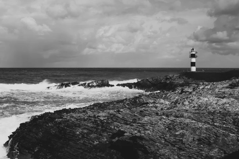 a black and white photo of a lighthouse on a rocky shore, a black and white photo, pexels contest winner, gloomy weather. high quality, puerto rico, pembrokeshire, beautiful daylight