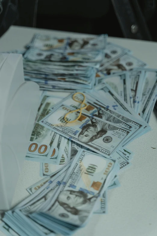 a pile of money sitting on top of a table, close to the camera, promo image, multiple stories, teddy fresh