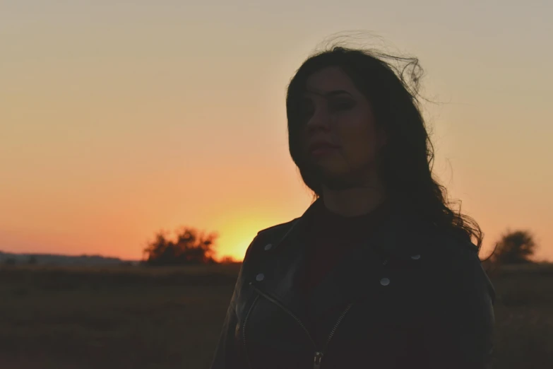 a woman standing in a field at sunset, an album cover, pexels contest winner, realism, looking to the side off camera, alanis guillen, still from a music video, profile image