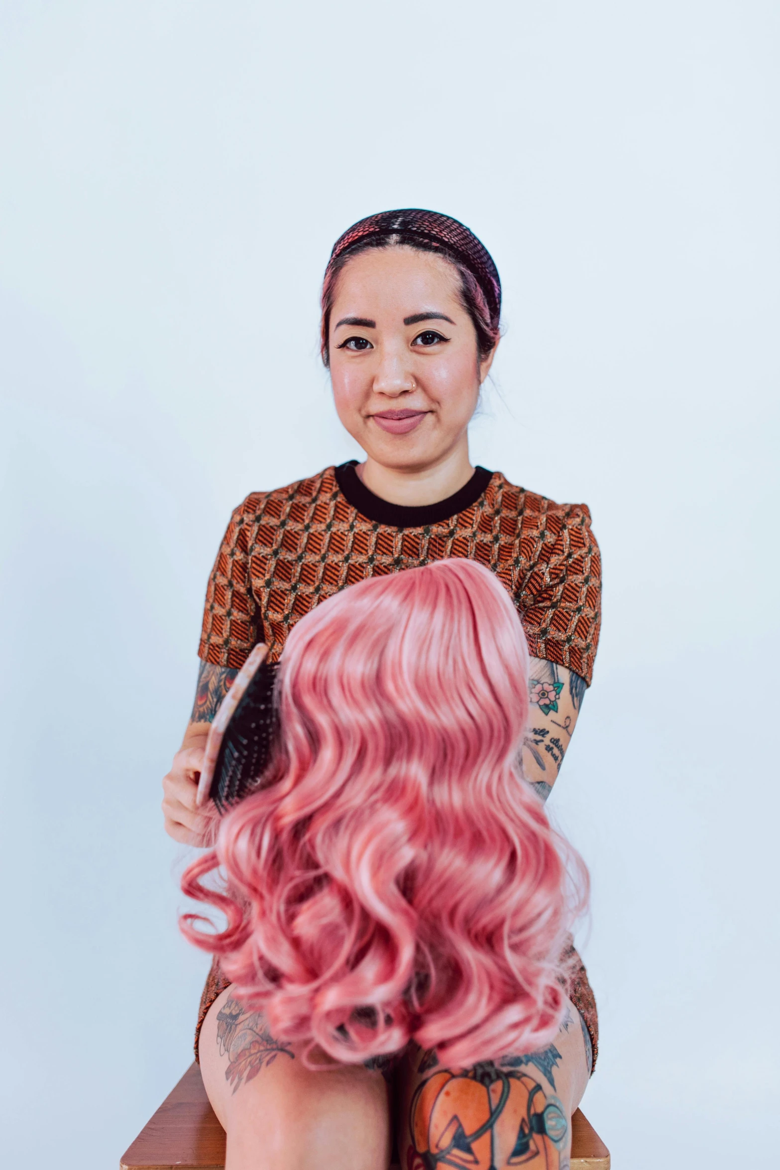 a woman with pink hair sitting on a stool, cross section of mannequin head, jen yoon, wavy hair, pictured from the shoulders up