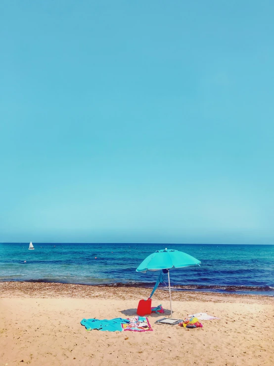 a blue umbrella sitting on top of a sandy beach, pexels contest winner, profile image, agrigento, instagram story, crystal clear sea