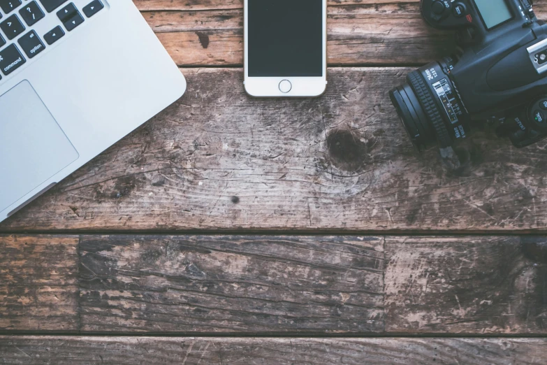 a laptop computer sitting on top of a wooden table, a picture, trending on pexels, art photography, phone camera, background image, vintage film stock, high quality image”