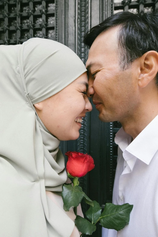 a man kissing a woman with a rose in her hand, hurufiyya, high forehead, malaysian, face covered, square