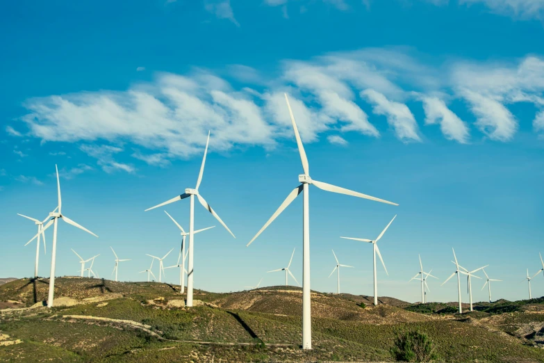 a group of wind turbines sitting on top of a hill, pexels contest winner, twirly, blue skies, profile image, high quality product image”