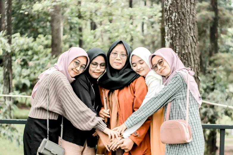 a group of women standing next to each other, a picture, inspired by Mym Tuma, pexels contest winner, hurufiyya, hijab, background image, best friends