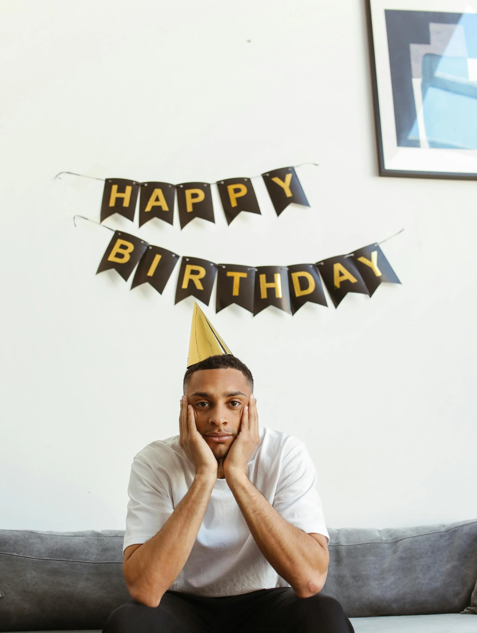 a man sitting on a couch wearing a party hat, pexels, happening, jaylen brown, 😭🤮 💔, happy birthday, sad men