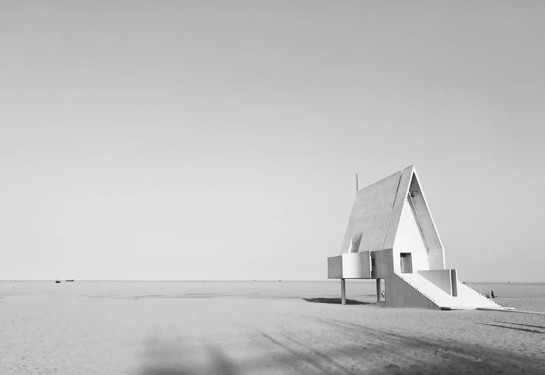 a black and white photo of a building on a beach, unsplash contest winner, minimalism, futuristic church, tiny house, white pale concrete city, minimalistic house in the wood