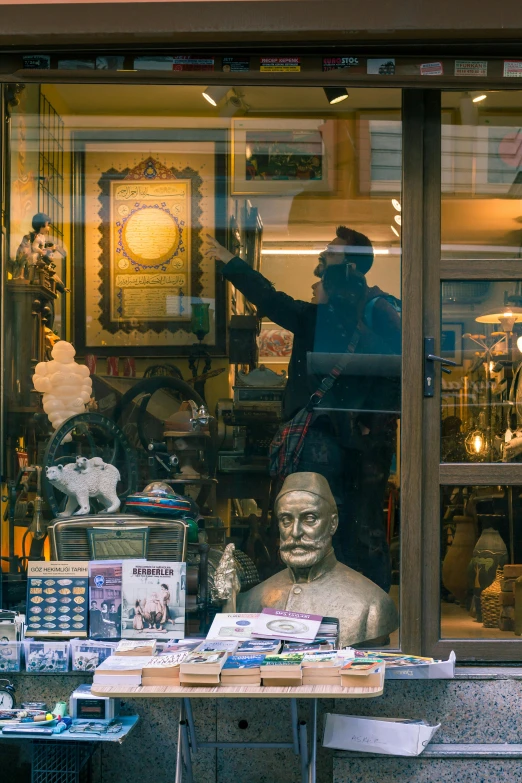 a store front with a statue in the window, many treasures, looking through a window frame, street scene, highlight