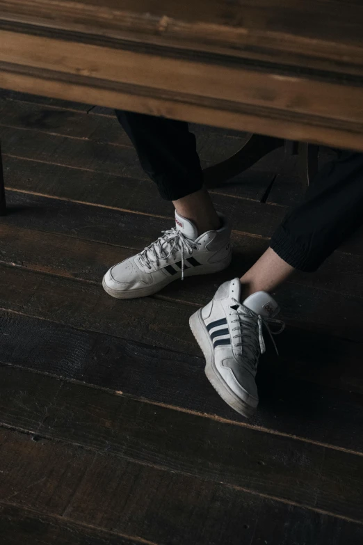 a person sitting on top of a wooden bench, by Adam Marczyński, trending on unsplash, photorealism, white adidas pants, sitting on a store shelf, sneaker design, on a white table