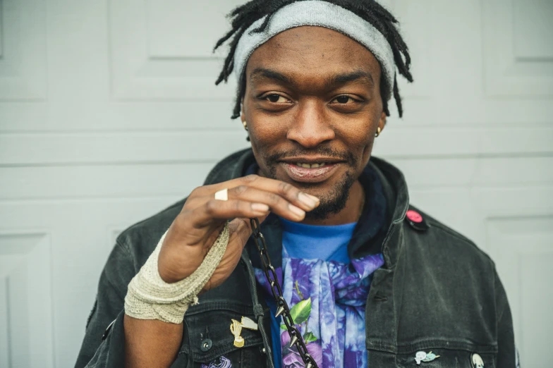 a man with dreadlocks standing in front of a garage door, a portrait, by Winona Nelson, unsplash, playboi carti and lil uzi vert, choke smirk smile grin, flower power, video game dunkey