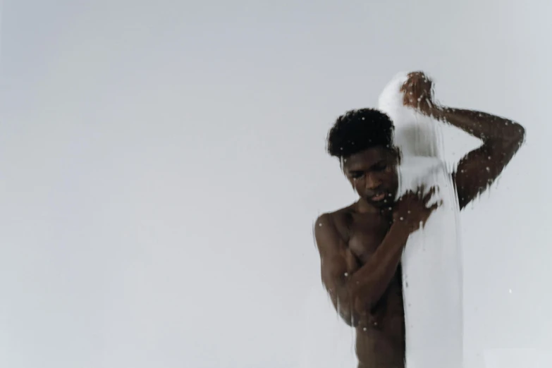 a man that is standing under a shower, by Matija Jama, black skin, white foam, background image, cinematography photo