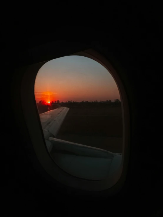 a view of a sunset through an airplane window, by Sudip Roy, taken in 2 0 2 0, runway photo, high quality image