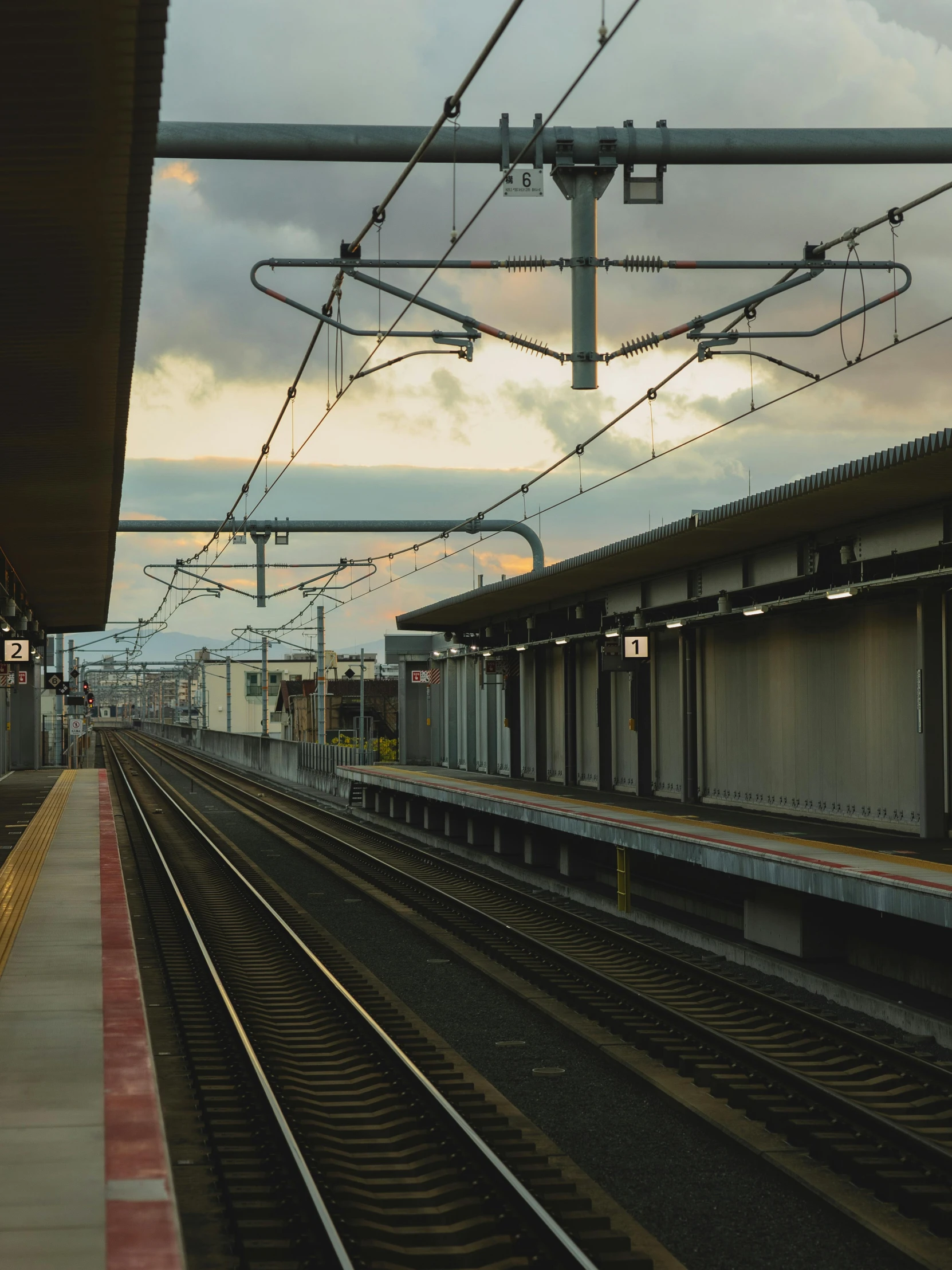 a train station with a train on the tracks, by Carey Morris, unsplash, skyline showing from the windows, caulfield, low quality photo, 4 k cinematic still