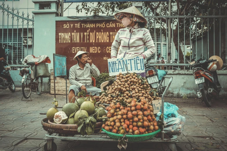 a woman standing next to a pile of fruit, by Sam Dillemans, pexels contest winner, emma watson vietnam door gunner, in the middle of the city, cart, 🦩🪐🐞👩🏻🦳