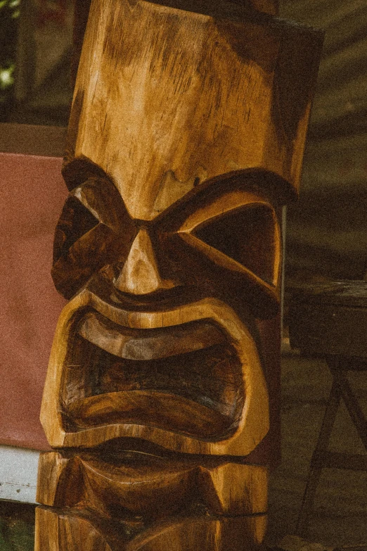 a wooden tiki sitting on top of a table, rugged face, intimidating glare, te pae, 2019 trending photo