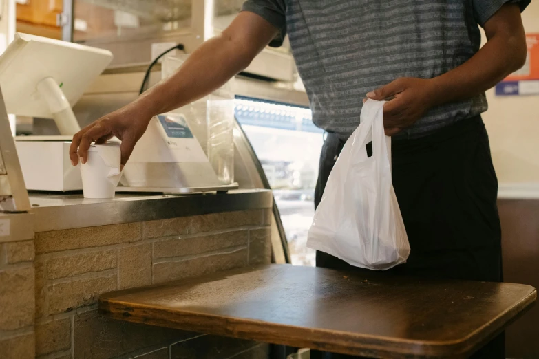 a man that is standing in front of a counter, bags on ground, serving suggestion, profile image, thumbnail