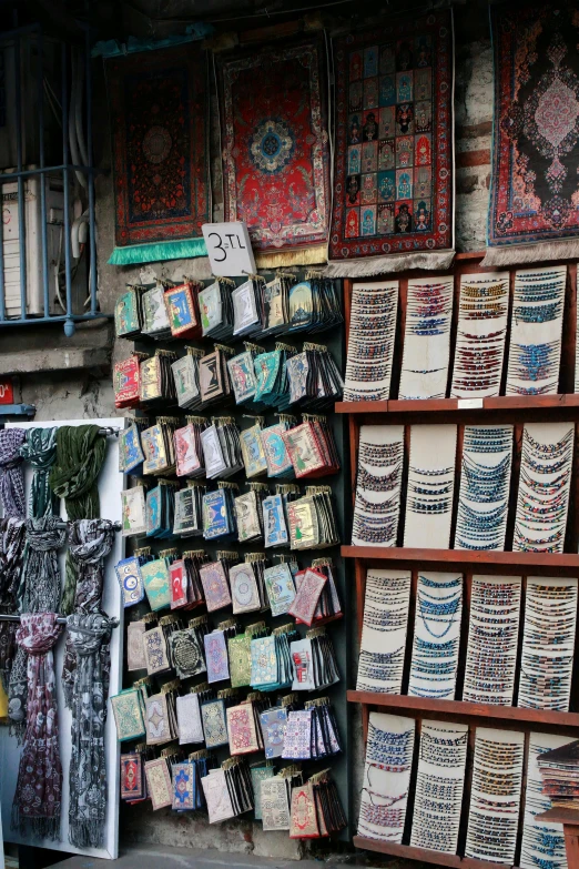 a store filled with lots of different types of rugs, a silk screen, by Emanuel Witz, trending on unsplash, cloisonnism, books covered in jewels, tel aviv street, taken in the late 2010s, cloth banners